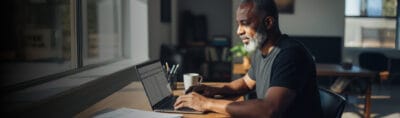 Empreendedor trabalhando no notebook em casa, representando quem vai abrir MEI pela internet